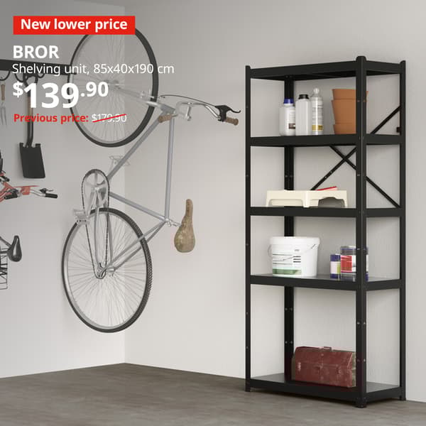 A BROR shelving unit in black is being used to place paint supplies and tool box. Red tag with white text that reads "New lower price". White text overlay image that reads "BROR, Shelving unit, 85x40x190 cm. Price at $139.90, previous price was $179.90"