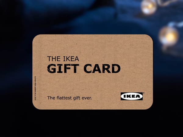 A brown IKEA Gift card is placed in front of dark blue background.