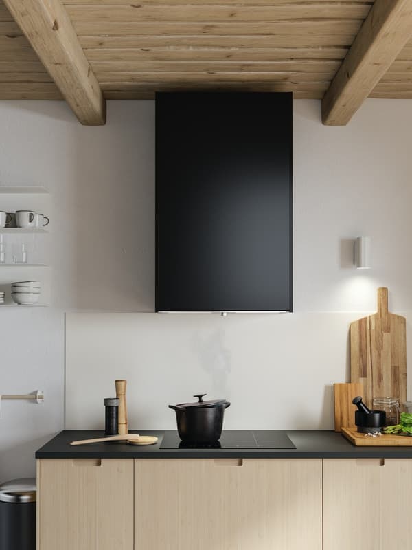 A built-in extractor hood with an anthracite door, a matte anthracite worktop and light bamboo drawer fronts.