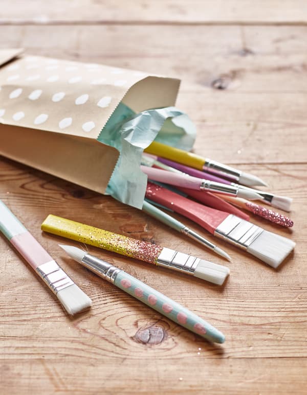 A bunch of hand-painted paint brushes lay in a gift bag.