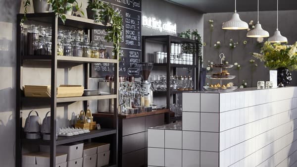 A business with a counter and racking with many organization contaners lined along the unit.