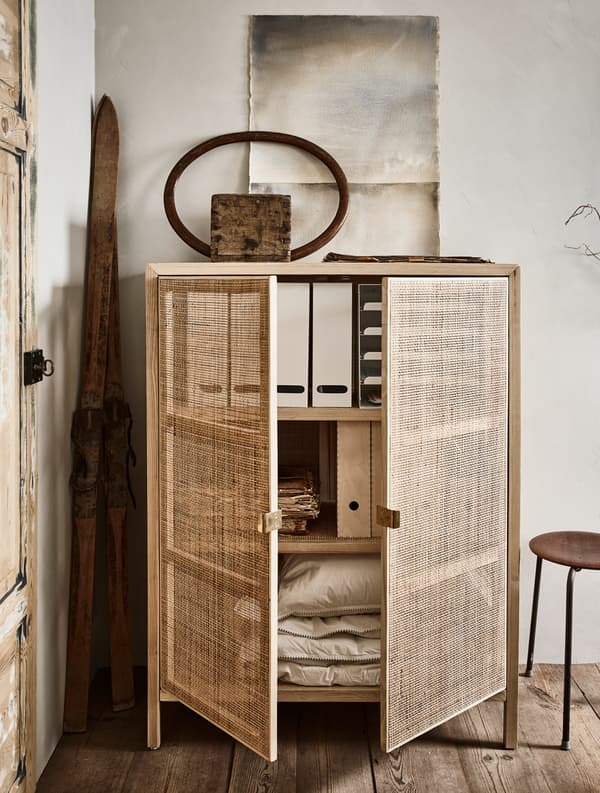 A cabinet holds magazine files, paper work, and extra bed linens.