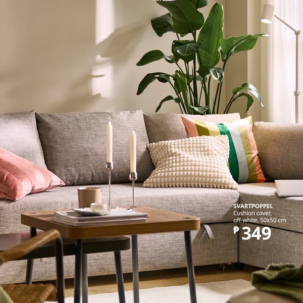 A calm beige living room with a textured sofa, colorful cushions, leafy plant, and candlelit coffee table; an ad highlights an off-white cushion cover.