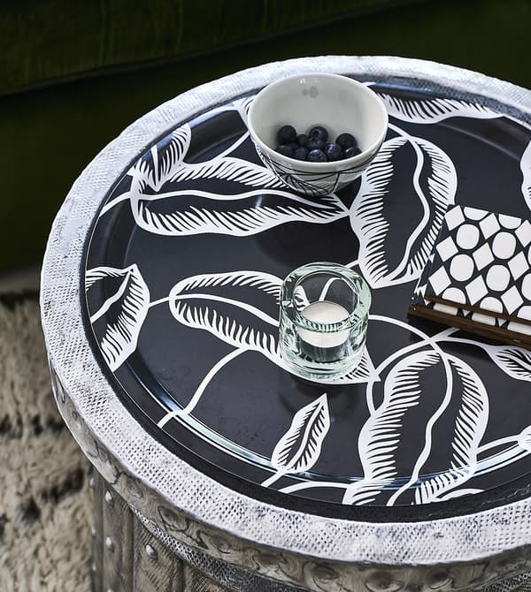 A candle and bowl on a tray, with a black and white motif.
