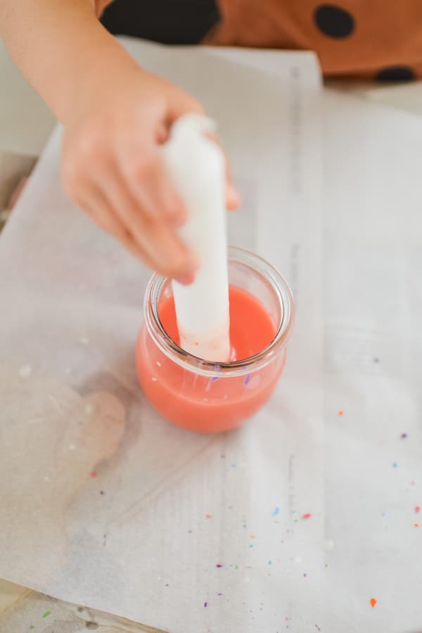 A candle dipped in orange wax paint