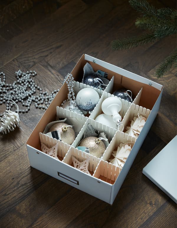 A cardboard box, with compartments, filled with holiday decorations.
