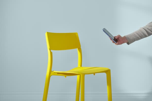 A chair that is currently being photographed by someone with a smartphone