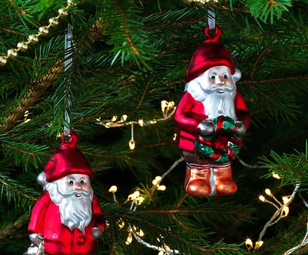 A child decorating a Christmas tree with red santas