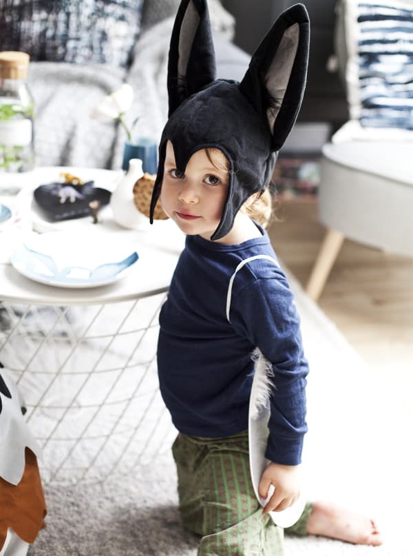 A child in fancy dress in the living room.