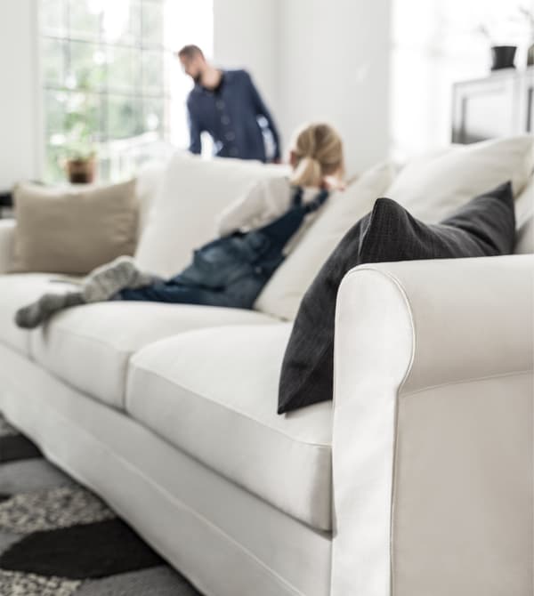 A child kneeling on a light-coloured sofa.