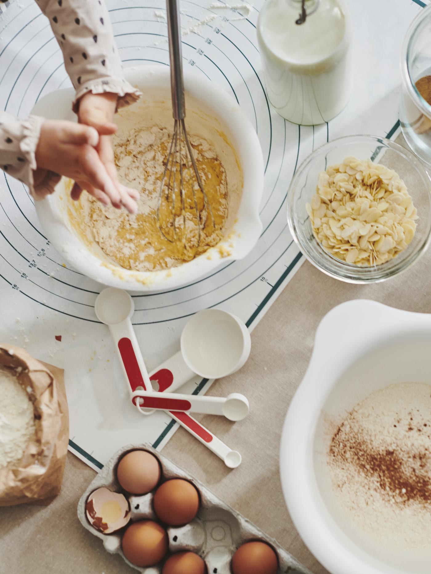 A child mixing dough in a white bowl
