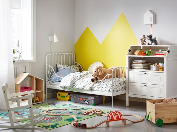 A children's bedroom with an IKEA MINNEN white extendable bedframe and SUNDVIK white changing table.