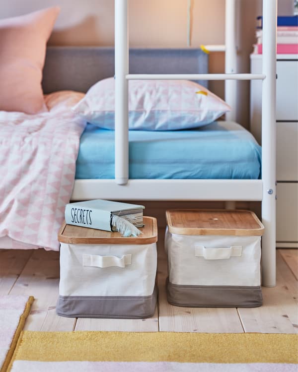 A children's room where RABBLA boxes with bamboo lids are pulled out from the bottom bed of a white bunk bed.
