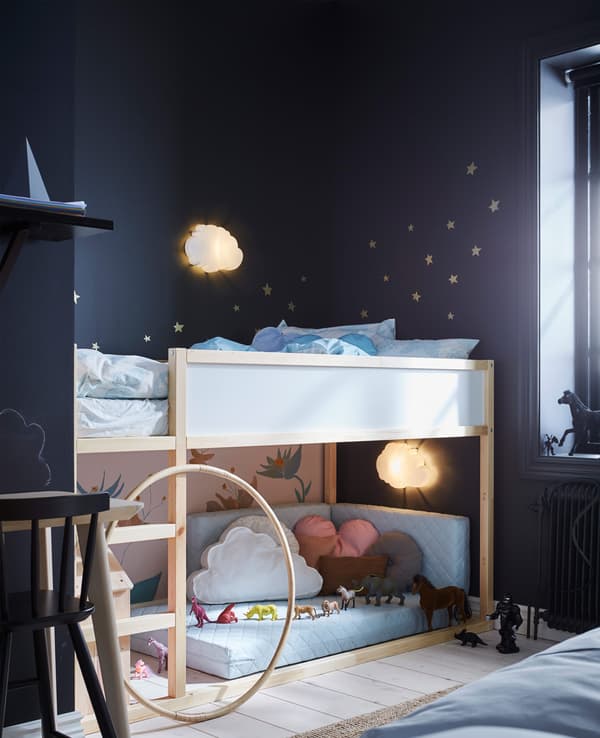 A child’s area in a shared bedroom with a reversible loft bed that has sleeping space on top and a play area underneath