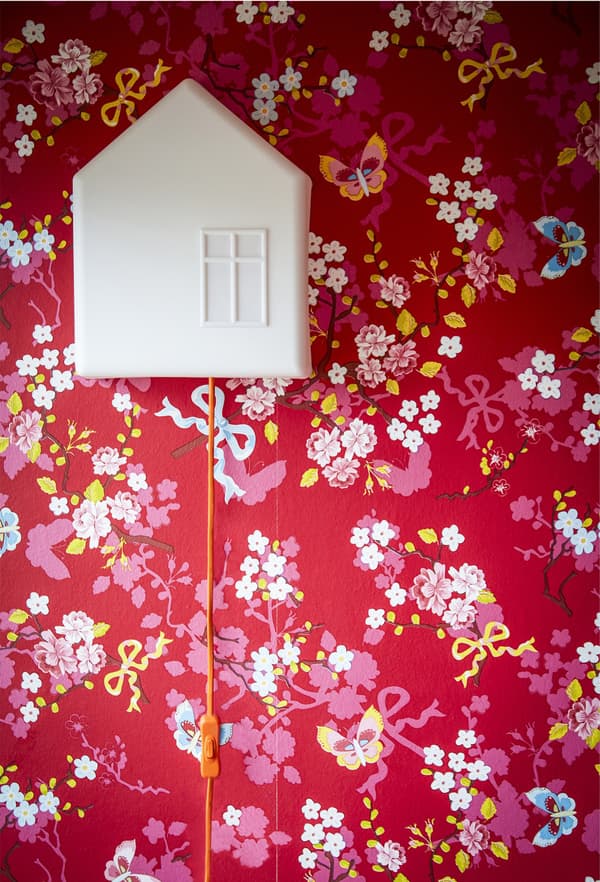 A child’s lamp on a red patterned wall.