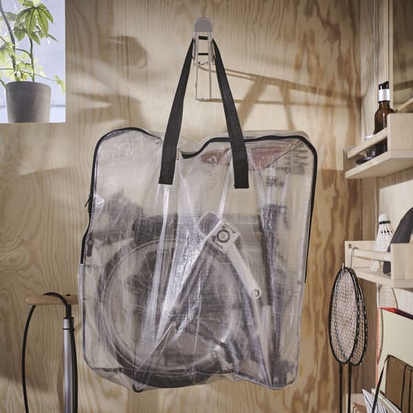 A clear storage bag hanging on a wall with bike accessories inside.