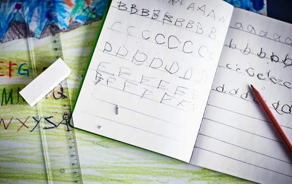 A close-up image of a notebook with children’s handwriting as they practice the English alphabet.