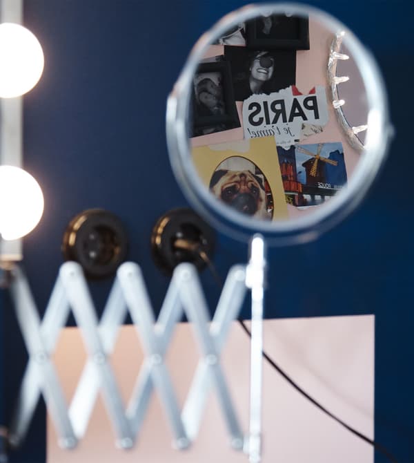 A close-up image of an IKEA GRUNDTAL cart stocked with blowdryers, curling irons, and other accessories.