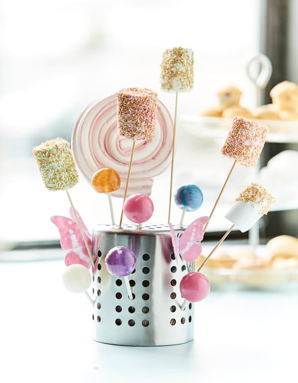 A close-up image of an IKEA ORDNING utensil holder turned upsed down and used as a holder for lollipops.