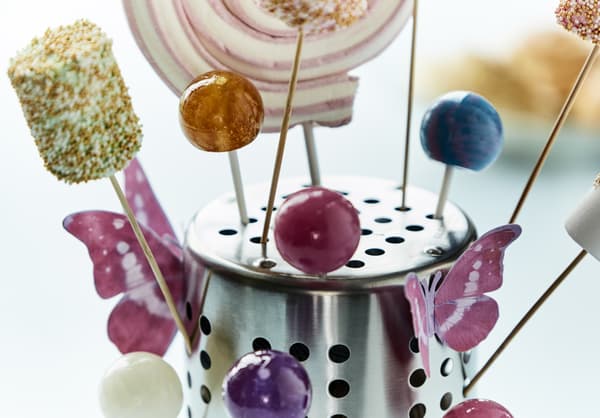 A close-up image of an IKEA ORDNING utensil holder turned upsed down and used as a holder for lollipops.