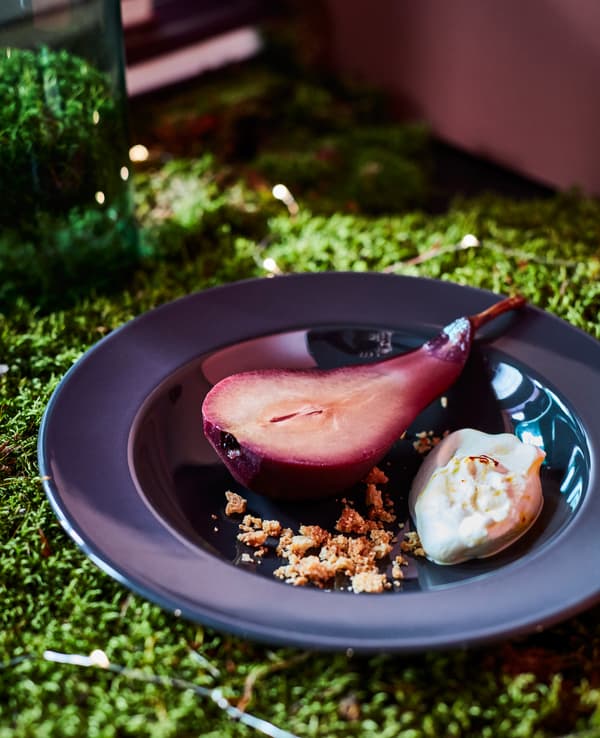 A close-up image of glögg-poached pears with whipped saffron cream.
