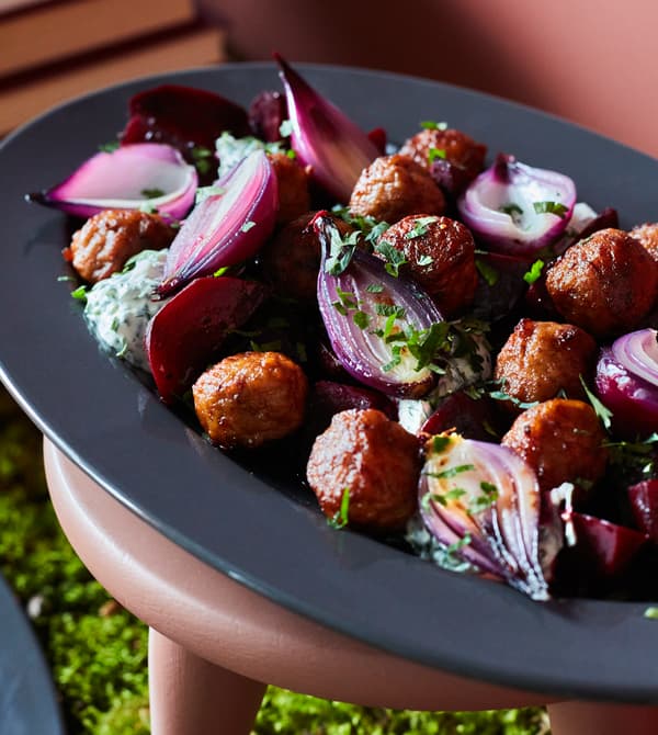 A close-up image of meatballs with salt-roasted beetroot, caramelised onions and crème fraîche.