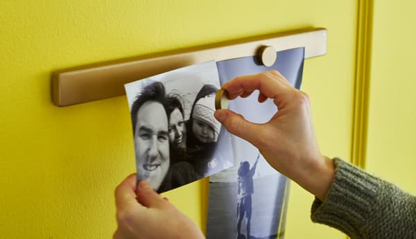 A close-up image of someone placing a picture on a magnetic knife rack.