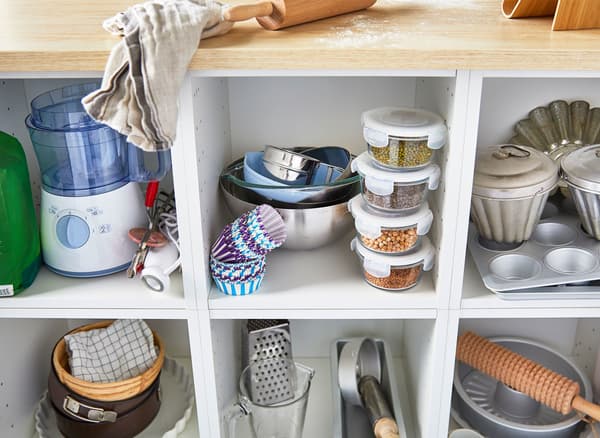 A close-up image shows baking tools stored on the shelves of a large kitchen island.