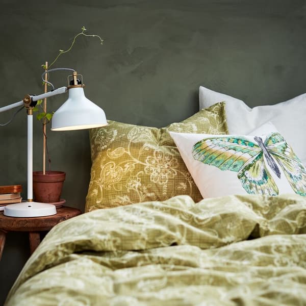 A close up of a bed with JUNIMAGNOLIA bed linen and a tactile VIGDIS cushion.