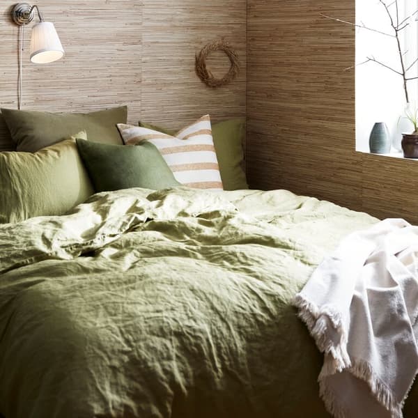 A close up of a bed with PUDERVIVA bed sheets, pillow cases and soft KNIPPARV cushions.