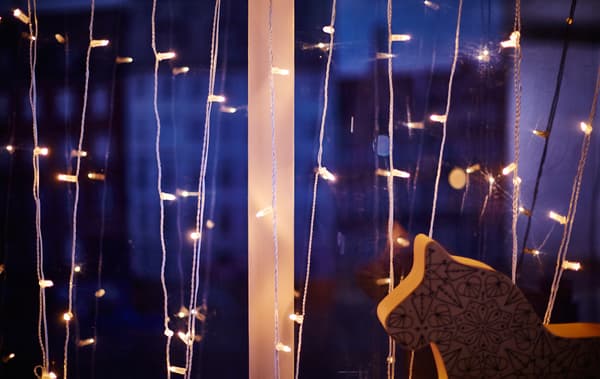 A close-up of a lighting chain strung in zig-zag pattern in a window.