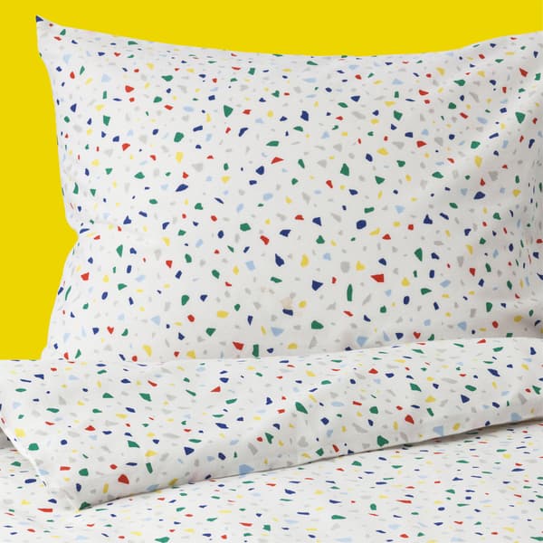 A close-up of a pillow and duvet with colourful mosaic print.