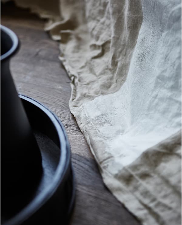  A close-up of a rough, raw fabric painted with a bold white stripe.