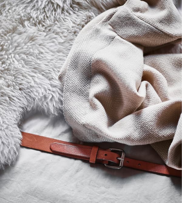 A close-up of a sheepskin and soft throw on seating made from mattresses.