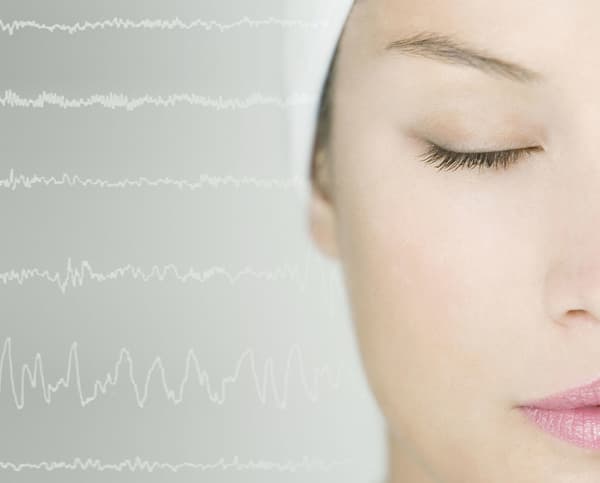 A close up of a woman's face with sound waves behind.