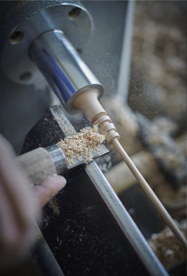 A close-up of a woodturning machine in use.