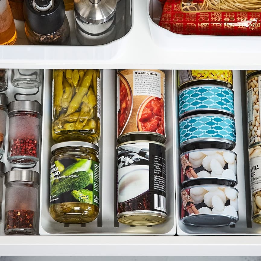 a close-up of an open drawer with cans tins and spices organisation