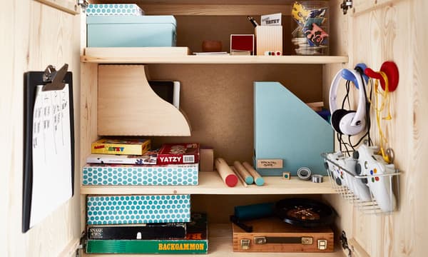A close-up of an organized IVAR cabinet that contains lots of games, boxes and entertainment.