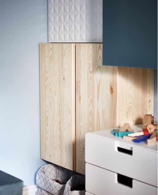 A close-up of different storage cabinets with an untreated pine IVAR cabinet in focus.