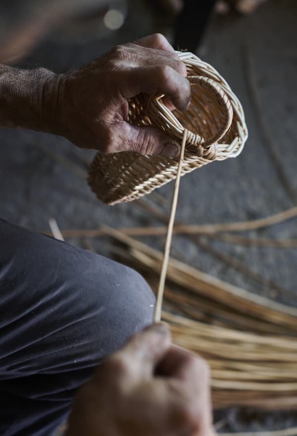 A close-up of hands working with cane.