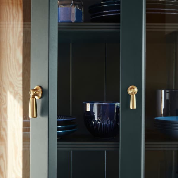 A close-up of LOMMARP cabinet with glass doors in dark blue-green with a drop handle for traditional-looking storage.