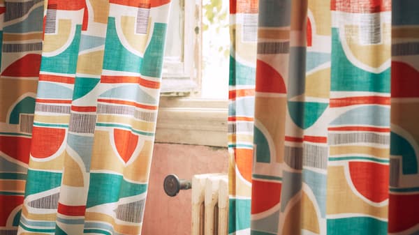 A close-up of MARTORN curtains with a multi-coloured graphic pattern that looks like it could be taken from the 1960s.