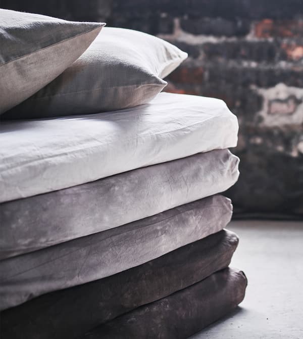 A close-up of the corner of a stack of mattresses made into a sofa-style chaise.