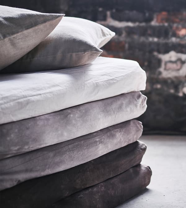 A close-up of the corner of a stack of mattresses made into a sofa-style chaise.
