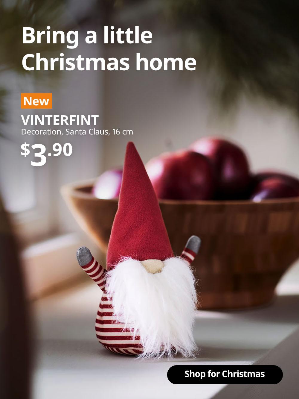 A close-up on a Santa Claus/striped red VINTERFINT decoration on the window ledge. On the top left corner, a orange tag with white text that reads 'New', followed by white text overlaying image that reads 'VINTERFINT, Decoration, Santa Claus, 16 cm, $3.90'.