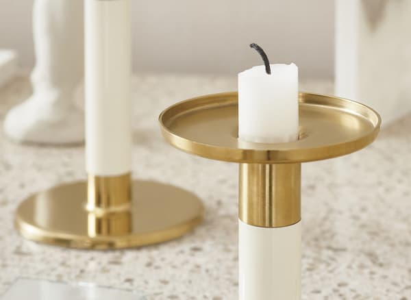 A close-up on an ivory and gold-coloured candlestick.