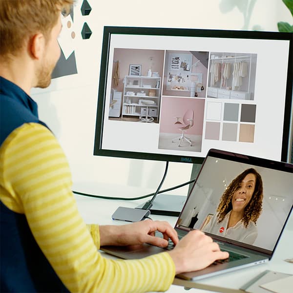 A close-up on two persons looking at photos of interiors and samples laid out on a white table.