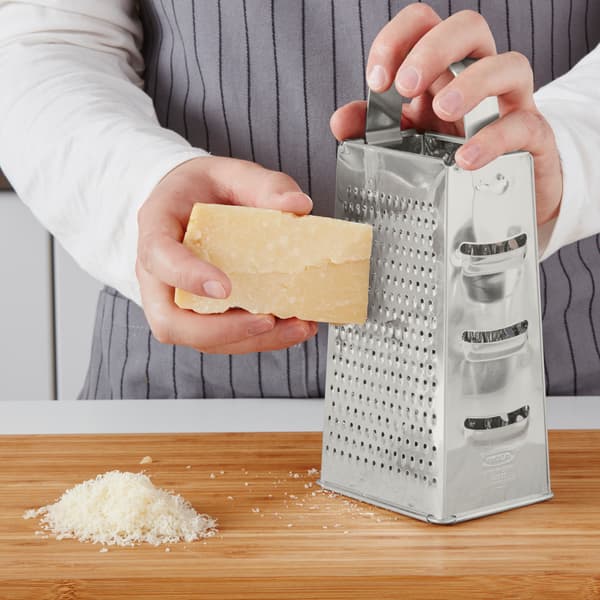 A close up picture of a person grating cheese.