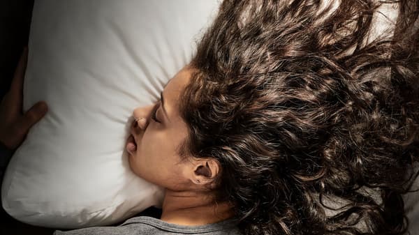 a close up shot of a person sleeping on their stomach