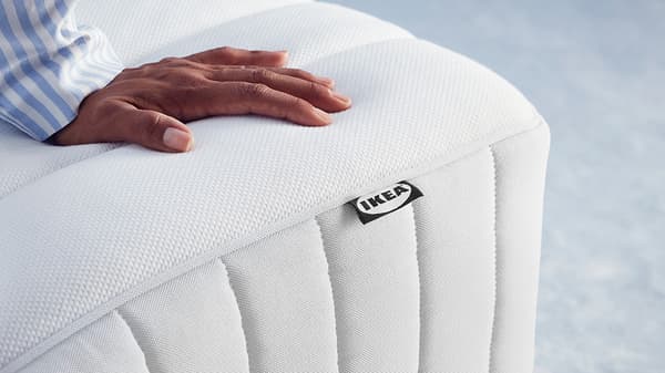 a close up shot of a person's hand on top of a mattress